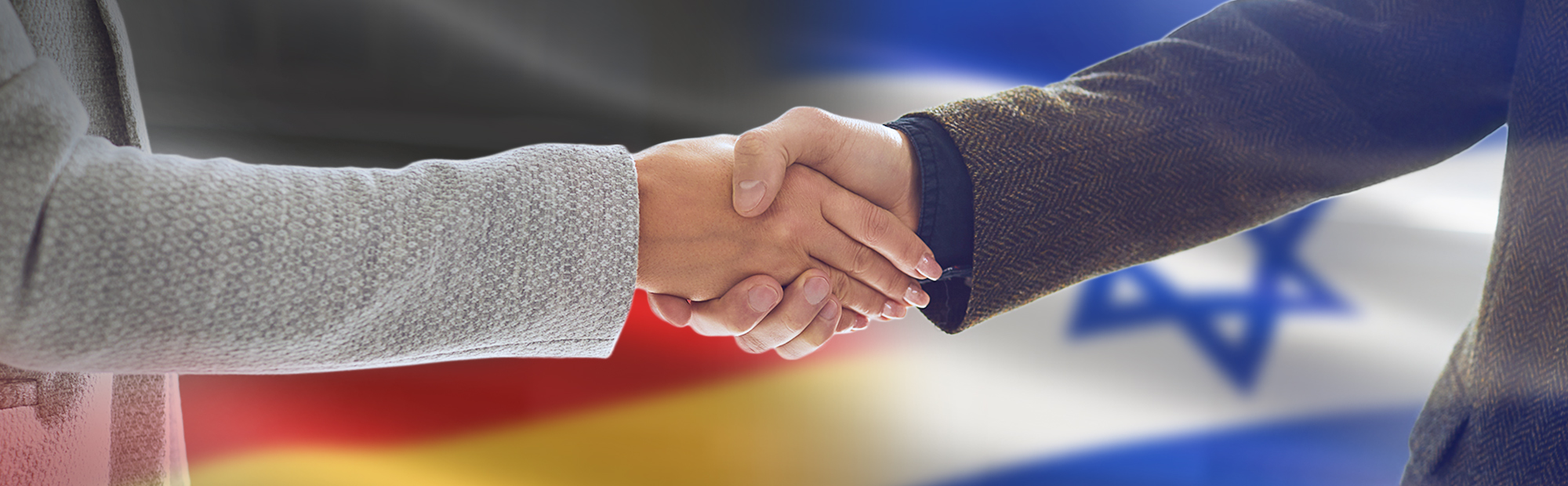 Eine Frau und ein Mann geben sich die Hand. Im Hintergrund ist die deutsche und israelische Flagge abgebildet.